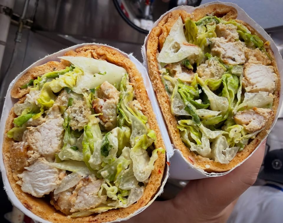 Two pita sandwiches, cut in half, filled with chicken, lettuce, and creamy dressing.